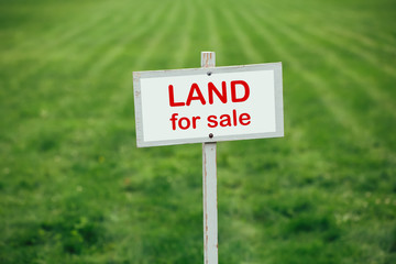 land for sale sign against trimmed lawn background