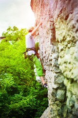 The girl climbs the rock.
