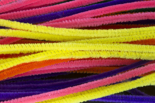 This is a photograph of Blue,Green,Purple,Orange,Pink and Yellow pipe cleaners background
