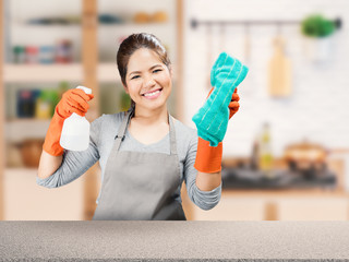 asian housewife holding spray bottle and rag with kitchen background