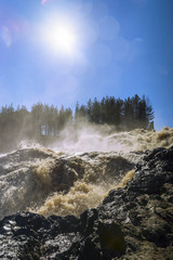 Picturesque waterfall in sunny day, vertical