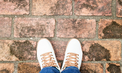 White sneakers from an aerial view on brick floors. Top view.