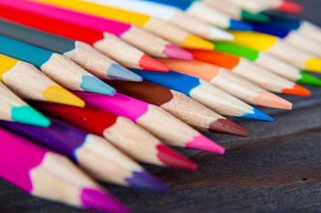 Multicolor pencils, on a wooden white background, close up