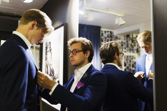 Tailor fitting man's suit