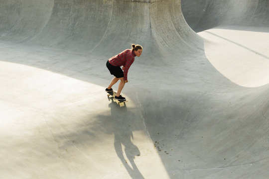 Full length of young woman skateboarding in skate park