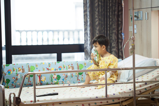little boy wearing oxygen mask in hospital ward