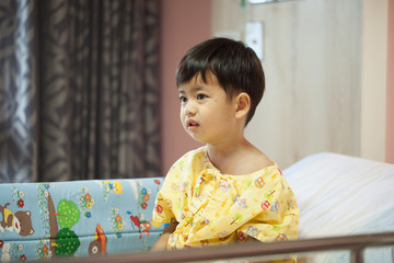 Patient boy sitting on hospital bed