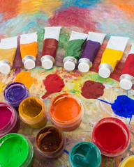 Fototapeta premium Paints, brushes and palette on a color background. The workplace of the artist. Banner for school