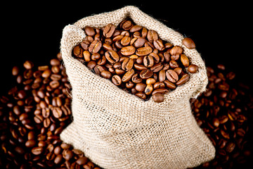 The sack of coffee on wooden background