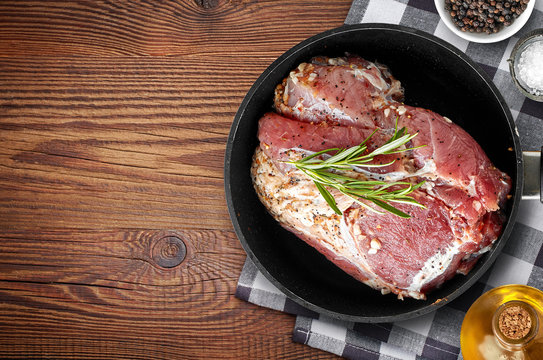 raw marinated meat on cooking pan