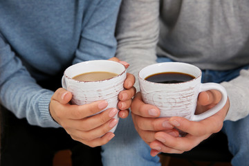 Man and woman holding coffee cups