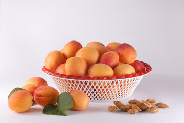 Apricots in a bowl and a few apricots and pits