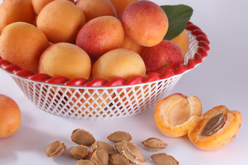 Apricots in a bowl and cut apricot and pits