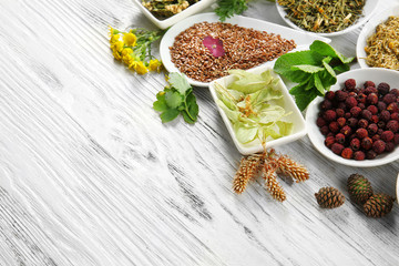 Natural flower and herb selection in ceramic bowls on wooden background