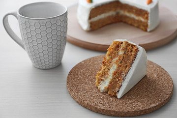 Tasty slice of carrot cake on cork plate