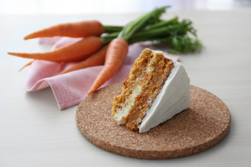 Tasty slice of carrot cake on cork plate
