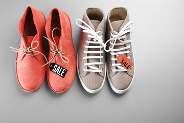 Grey and red shoes on grey background. Sale concept