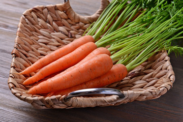 Fresh carrots in wicker tray, closeup