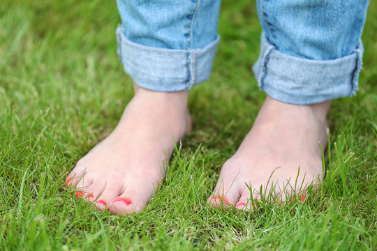Woman standing  barefoot  on green grass background