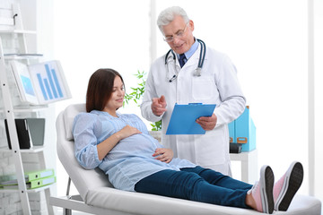 Young pregnant woman visiting doctor