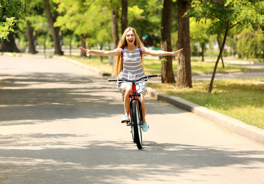 Beautiful girl riding bike on street