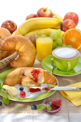 Gedeckter Frühstückstisch mit Croissants und Cappuccino - Breakfast table with a cup of cappuccino and croissants