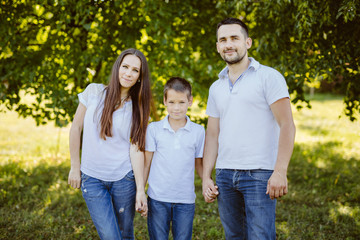 Fototapeta premium Family of Three Having Fun Together in a Field.Concept of friendly family.
