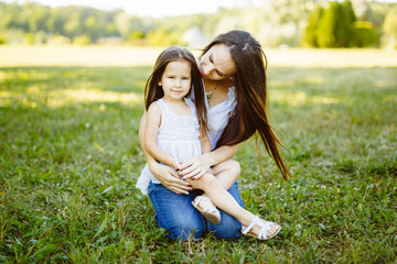 Happy mother and daughter laughing together outdoors