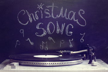 old Christmas song/ retro old turntable with a plate on the background of the inscription in chalk...