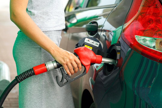 Woman Fills Petrol Into The Car At A Gas Station