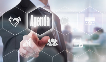 A businessman selecting a Agenda Concept button on a hexagonal screen