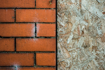Close-up detail of brick wall building with a boarded up window
