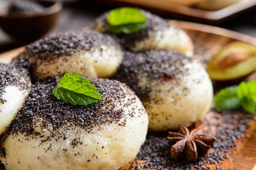Sweet steamed dumplings with a plum jam sprinkled with ground poppy seeds