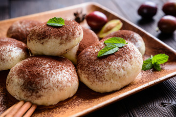 Sweet steamed dumplings with a plum jam, sprinkled with cocoa powder