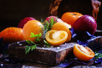 Whole and cut orange tomatoes, dill, parsley, purple basil, vint