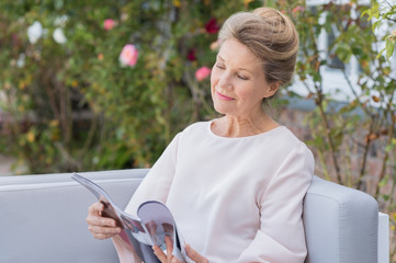 Senior woman reading magazine