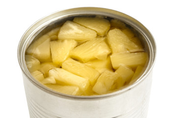 Pieces of pineapple in a tin in perspective on white.
