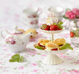 Cream puffs cakes or profiterole filled with whipped cream served with strawberries in plateau