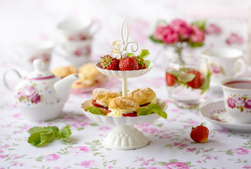 Cream puffs cakes or profiterole filled with whipped cream served with strawberries in plateau