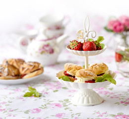 Cream puffs cakes or profiterole filled with whipped cream served with strawberries in plateau
