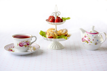 Cream puffs cakes or profiterole filled with whipped cream served with strawberries in plateau