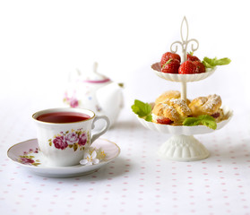 Cream puffs cakes or profiterole filled with whipped cream served with strawberries in plateau