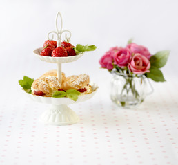 Cream puffs cakes or profiterole filled with whipped cream served with strawberries in plateau
