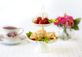 Cream puffs cakes or profiterole filled with whipped cream served with strawberries in plateau
