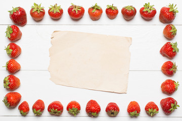 Strawberry frame and paper sheet on table