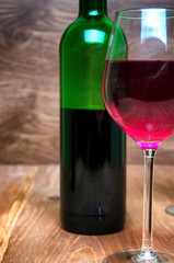 Wine glass and bottle on a wooden background