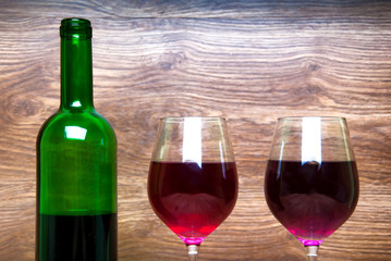 Wine glass and bottle on a wooden background