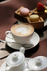 Cup of cappuccino and macaroons