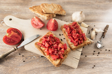 bruschetta with tomatoes on rustic, old wood background