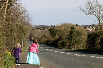 Little girls waiting expectantly by side of the road